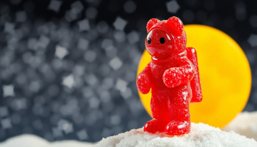 AI generated image of An astronaut in a red space suit  made gummy bear encrusted with large sugar